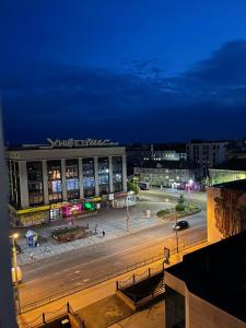 une rue de la ville la nuit avec un grand bâtiment dans l'établissement 4-км в центрі міста, à Rivne