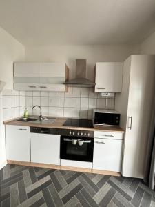 a kitchen with white cabinets and a stove top oven at Ostsee Ferienhaus Usedom Familie Stopp Haus 22 in Lütow