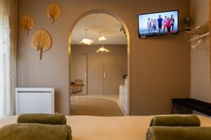 a living room with an archway and a television on the wall at Love Room Suite Bali - Auray en Bretagne in Brech