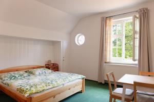 1 dormitorio con 1 cama y reloj en la pared en Splavský zámeček en Staré Splavy