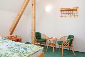 Zimmer mit Stühlen, einem Tisch und einem Bett in der Unterkunft Splavský zámeček in Staré Splavy