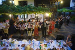 un gruppo di persone che si trovano di fronte a un gruppo di tavoli di Strannopriemnitsa Guest House a Bozhentsi