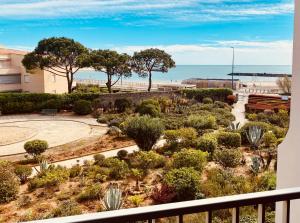 une vue d'un jardin depuis un balcon avec l'océan en arrière-plan dans l'établissement Sète-Vue mer-#monabridelaplage, à Sète