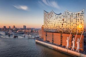 ein großes Gebäude neben dem Wasser in der Unterkunft City Apartment Hotel Hamburg in Hamburg