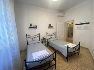 Duas camas individuais num quarto com um corredor em Ad Agio Apartments em Pisa