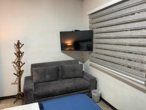 a living room with a chair and a flat screen tv at El solar casa hotel in Manizales