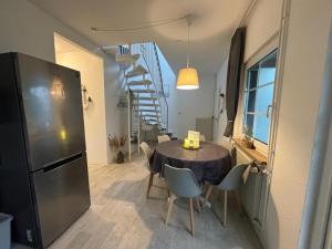 une cuisine et une salle à manger avec une table et un escalier dans l'établissement Ferienhaus Usedom Familie Stopp Haus 23, à Lütow
