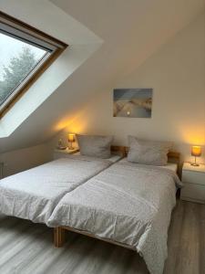 two beds in a attic bedroom with a window at Ferienhaus Usedom Familie Stopp Haus 23 in Lütow