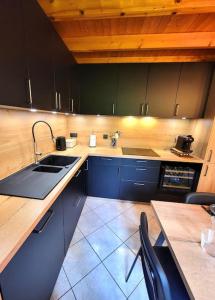 a kitchen with blue cabinets and a sink and a table at Chalet Goutelle, paisible en pleine nature in Gérardmer