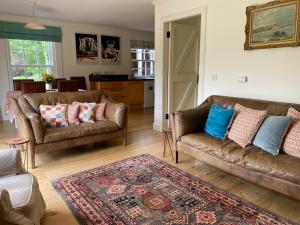 una sala de estar con 2 sofás y una alfombra en Private detached cottage sleeps 4 en Crieff