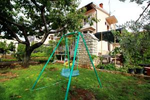 a blue swing in the yard of a house at Apartment in Porec/Istrien 10030 in Poreč