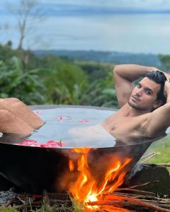un hombre sentado en un jacuzzi sobre un fuego en Bintana sa Paraiso Binunsaran en Mambajao