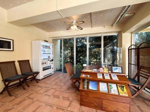 Imadomariにあるpension sunset beach - Vacation STAY 41230vの椅子、テーブル、冷蔵庫が備わる客室です。