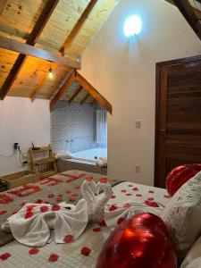 a bedroom with a bed with red hearts on it at Chalé Pinheiros da Mantiqueira in Camanducaia