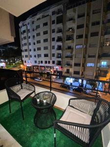 uma varanda com cadeiras e uma mesa e vista para a cidade em Marina apartment em Tânger