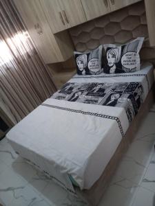 Una cama con cómics en las almohadas. en Appart Hicham, en Tánger