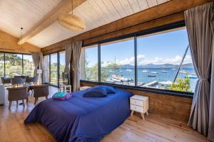 ein Schlafzimmer mit einem Bett und einem großen Fenster in der Unterkunft Le Lodge de la Presqu’île de Giens in Hyères