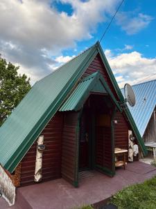 a small wooden building with a green roof at Durmitorske kolibe in Žabljak