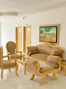 a living room with a couch and two chairs at Hotel Ginebra Sincelejo in Sincelejo