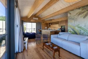 Le Lodge de la Presqu’île de Giens في هييريس: غرفة معيشة مع أريكة زرقاء ومطبخ