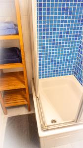 漢諾威的住宿－CENTRAL Apartment Hannover - Good & calm location - Contactless Check-in，浴室设有浴缸和蓝色瓷砖淋浴。