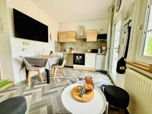 a living room with a table and a kitchen at Ostsee Ferienhaus Usedom Familie Stopp Haus 26 in Lütow