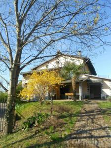 una casa bianca con un albero davanti di B&BTorre Cives a Vidracco