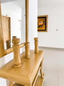 Hotel Ginebra Sincelejo في سينسليخو: طاولة خشبية في غرفة مع مرآة