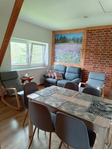 a living room with a table and a brick wall at Dom W Krokusach Pokoje Gościnne in Nowe Bystre
