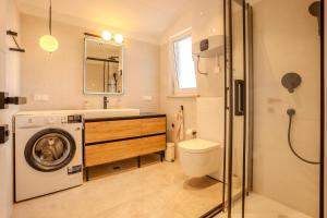 a bathroom with a washing machine and a toilet at Apartment Hrabrić in Njivice +22 photos