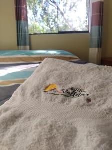 eine weiße Decke auf einem Bett mit Fenster in der Unterkunft Hotel El Gran Valletero in Cotahuasi