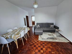 uma sala de estar com uma mesa e um sofá em Casa a Torre em Santa Cruz - Madeira