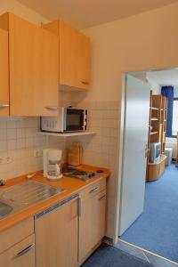 - une cuisine avec des placards en bois et un réfrigérateur blanc dans l'établissement FW Knütel Nr 57, à Burgtiefe auf Fehmarn 