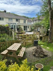 a wooden picnic table in a yard next to a fence at Plympton Annex - Apartment in Plymouth