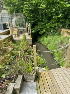 a bench sitting on a wooden bridge next to a stream at Plympton Annex - Apartment in Plymouth