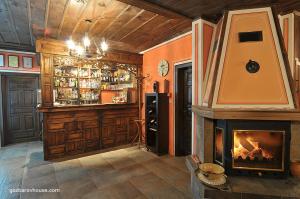 sala de estar con chimenea y bar en Gozbarov's Guest House en Koprivshtitsa