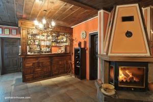 a living room with a fireplace and a bar at Gozbarov's Guest House in Koprivshtitsa