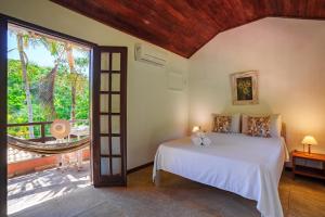a bedroom with a bed and a balcony at Pousada Casa Cactus Praia da Tartaruga Búzios in Búzios