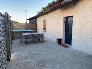 a patio with a table and chairs next to a building at Maison des romains in Villeneuve-sur-Lot