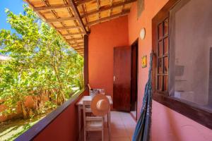 einen Balkon eines Hauses mit einem Tisch und einem Fenster in der Unterkunft Pousada Casa Cactus Praia da Tartaruga Búzios in Búzios