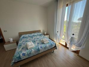 Un dormitorio con una cama y una ventana grande. en Moderni Appartamenti Appia Terracina, en Terracina