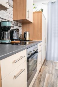 a kitchen with white cabinets and a stove top oven at Ferienwohnung Gold-Blick in Korbach