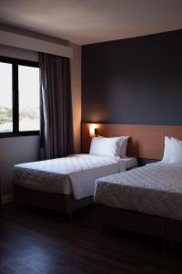Cette chambre comprend 2 lits et une fenêtre. dans l'établissement Comfort Hotel Presidente Prudente, à Presidente Prudente
