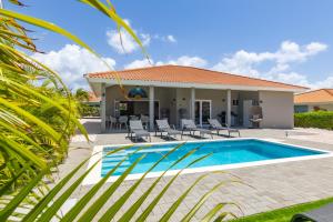 a villa with a swimming pool and a house at Villa Nisa - HOMEofEase - Villapark Fontein in Fontein