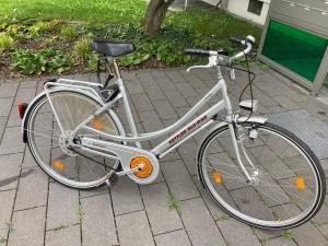 a white bike parked on a sidewalk at Premium City Apartment Dresden in Dresden