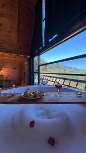 a bath tub with a plate of food and a glass of wine at sitiela bungalov kir evi in Çamlıhemşin