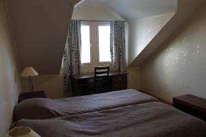 Schlafzimmer mit einem Bett, einem Schreibtisch und einem Fenster in der Unterkunft SResort Apartment with 4 bedrooms in Imatra