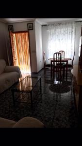 uma sala de estar com uma mesa e cadeiras e um sofá em Casa duplex em San Pedro del Pinatar