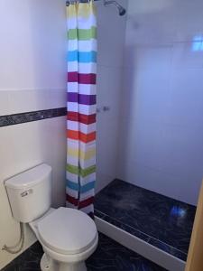 ein Badezimmer mit einem WC und einem farbenfrohen Duschvorhang in der Unterkunft Hotel El Gran Valletero in Cotahuasi