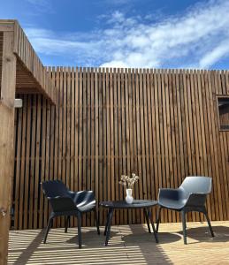 dos sillas y una mesa frente a una valla en Green Lodge, en Perros-Guirec